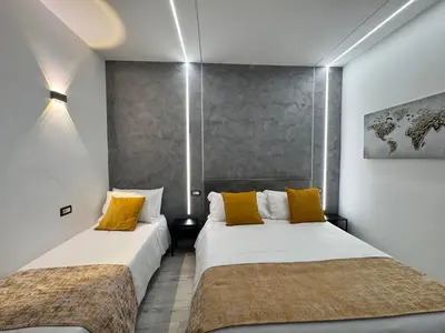 two beds in a room with white and yellow pillows at Turati Inn in Rome