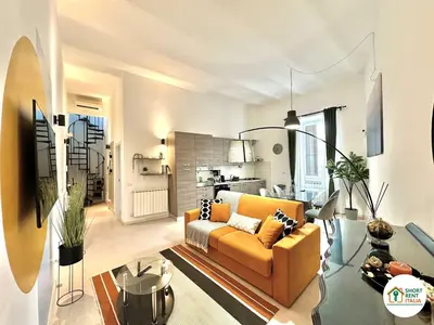 a living room with a yellow couch and a kitchen at Corso Francia - Exclusive House in Rome