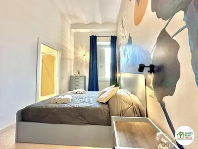 a bedroom with a bed with a painting on the wall at Corso Francia - Exclusive House in Rome