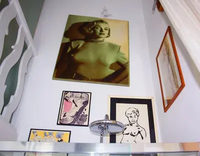 a wall with pictures and a picture of a woman at Colosseo Vintage Apartment in Rome