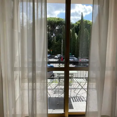 a window with white curtains and a view of a parking lot at Vatican New home in Rome in Rome