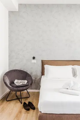 a bedroom with a bed and a chair at Elysium Suites Colosseo in Rome