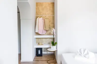 a bedroom with a white bed and a closet at Elysium Suites Colosseo in Rome