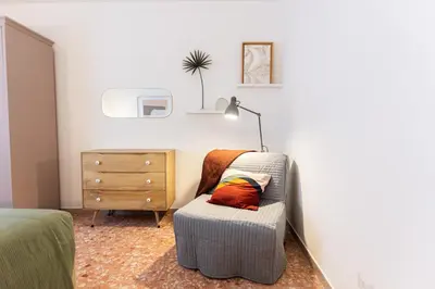 a bedroom with a chair and a lamp and a dresser at Casa Margherita in Rome