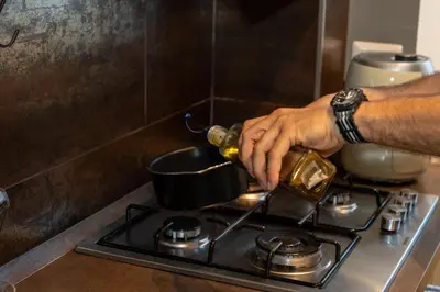 a person pouring a pot on a stove at CupolHome - Meraviglia A San Pietro in Rome