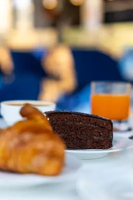 a piece of chocolate cake and a croissant on a plate at J Maluni City Hotel in Rome