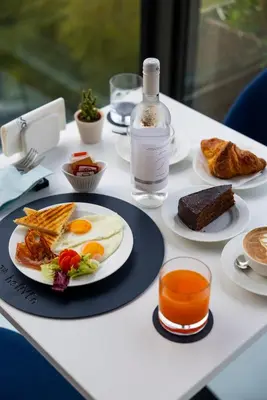 a table with plates of food and a bottle of water at J Maluni City Hotel in Rome