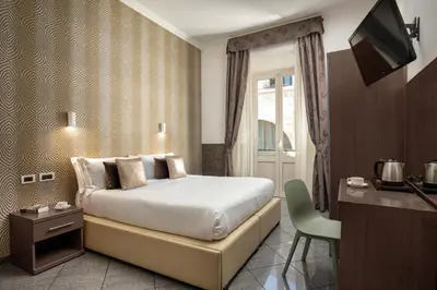 a bedroom with a bed and a desk and a television at Ciao Collection in Rome