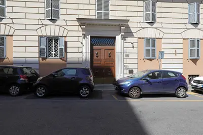 three cars parked in a parking lot in front of a building at Zelo Apartment by Nosdom Properties in Rome