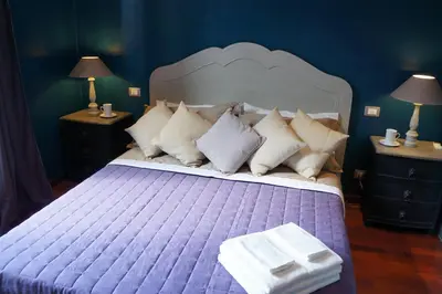 a bedroom with a large bed with purple sheets and pillows at A Casa Di Elle in Rome