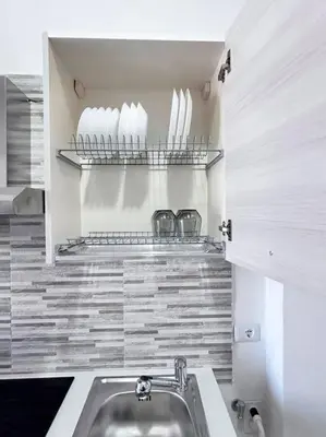 a kitchen with a sink and a shelf with dishes at Maison Monferrato in Rome