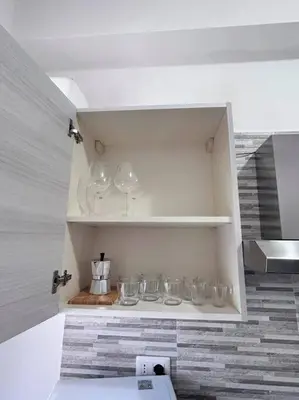 a kitchen with a bunch of wine glasses on shelves at Maison Monferrato in Rome