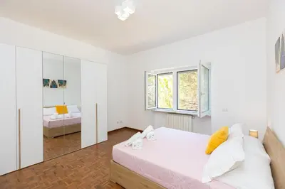 a white bedroom with a bed and a mirror at Baldo by Rental in Rome in Rome