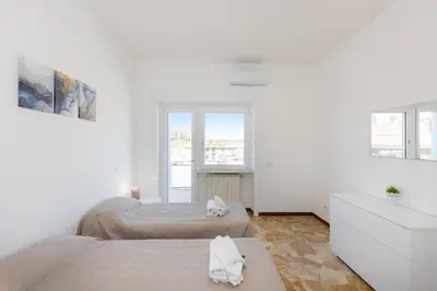 two beds in a bedroom with white walls and windows at Baldo by Rental in Rome in Rome