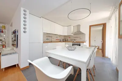 a white kitchen with a white table and chairs at Via dell'Orso Charme - My Extra Home in Rome