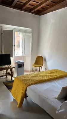 a bedroom with a bed with a yellow blanket on it at Navona Suite Rome - quite and view in Rome