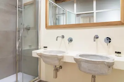 two sinks in a bathroom with a shower at Reginella Luxury Apartment in Rome