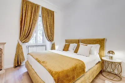 a white bedroom with a large bed with gold sheets at NEW Vatican BIG apartment - ROMEDREAMHOME in Rome
