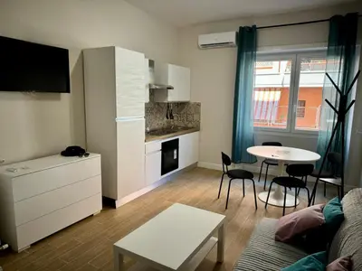a living room with a couch and a table and a kitchen at Premium One-Bedroom Apartment plus sofa bed, Near Vatican - newly renovated in Rome