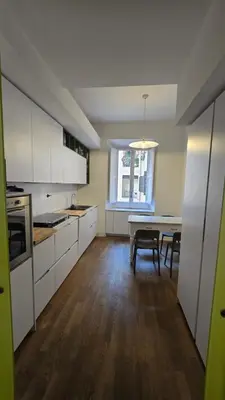 a kitchen with white cabinets and a table with chairs at Greta's house in Rome