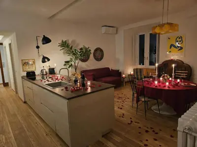 a kitchen and a living room with a table with candles at Home Rome Borsieri in Rome
