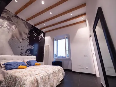 a bedroom with a bed with a large painting on the wall at ConTe Green House - 2 Apartments in Rome