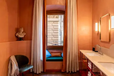 a bathroom with a window with a chair and a sink at ROMAC Baullari IV Large apartment in Campo de' Fiori in Rome