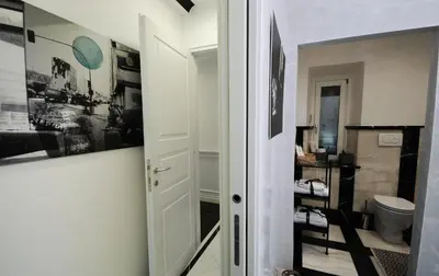 a bathroom with a door leading to a room with a toilet at Suite Spagna 29 in Rome