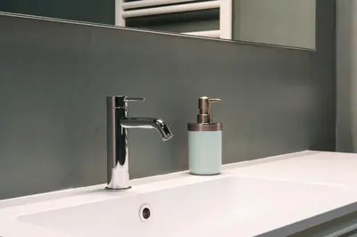 a bathroom sink with a faucet and a mirror at Cavalieri Suites Roma in Rome