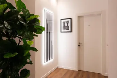 a hallway with a potted plant and a mirror at Cavalieri Suites Roma in Rome