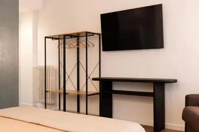a living room with a tv and a table at Cavalieri Suites Roma in Rome