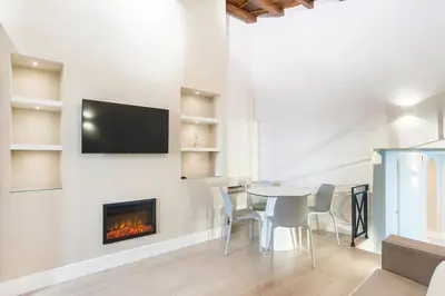 a dining room with a table and a fireplace at Ciambella Atmosphere by Rental in Rome in Rome