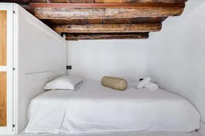 a bedroom with a white bed with wooden ceilings at Dream Home in Rome