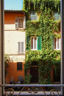 a building covered in ivy with a bench in front of it at C&A Apartments - Authentic Trastevere in Rome