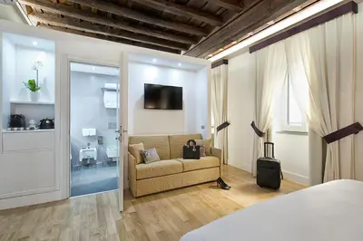 a bedroom with a couch and a tv in a room at Domus Libera in Rome