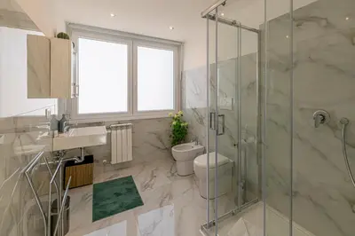 a bathroom with a toilet and a glass shower at Appia Antica Park - Apartment with Terrace in Rome
