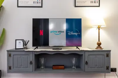 a tv on top of a grey entertainment center at Vicomoro House Trastevere in Rome