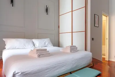 a bedroom with a white bed with towels on it at Vicomoro House Trastevere in Rome