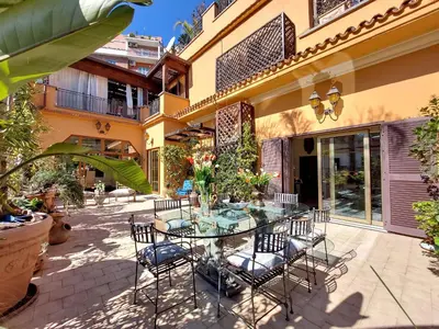 a patio with a table and chairs in front of a building at Luxury Trastevere Terraces in Rome