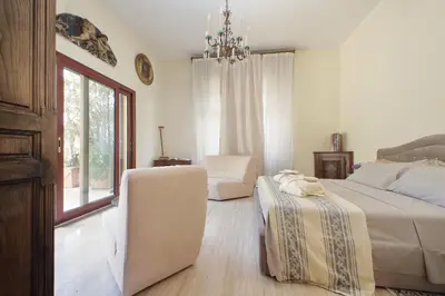 a bedroom with a bed and a chair and a window at Luxury Trastevere Terraces in Rome