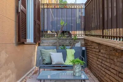a blue couch with pillows sitting on a balcony at iFlat Saint Peter Green Chic Brand New Apartment in Rome