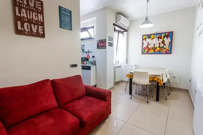 a living room with a red couch and a table at Naos C&G Hospitium in Rome
