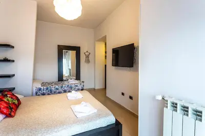 a room with a bed and a tv on a wall at Naos C&G Hospitium in Rome