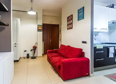 a living room with a red couch in a kitchen at Naos C&G Hospitium in Rome