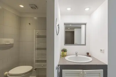 a bathroom with a sink and a toilet and a mirror at iFlat Colosseum Modern & Peaceful Design Apt in Rome