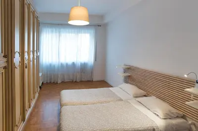 a bedroom with two beds and a large window at House in the City in Rome