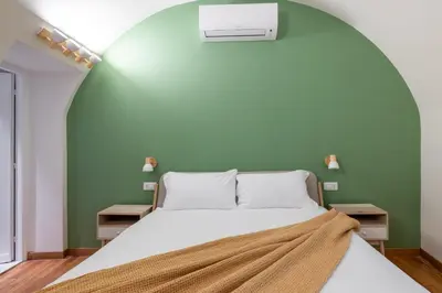 a bed in a room with a green wall at Charming 3 Bedroom Apartment in the Historic Center in Rome