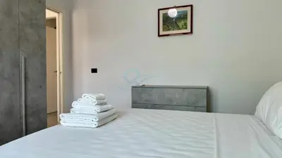 a stack of towels sitting on top of a bed at Contemporary Comfort Stylish Modern Apartment in Rome