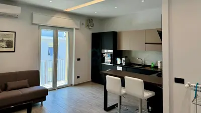 a kitchen and living room with a table and chairs at Contemporary Comfort Stylish Modern Apartment in Rome