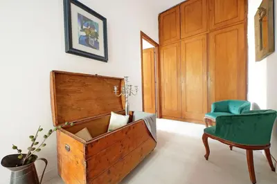 a room with a wooden box and a green chair at Eroi Spacious Apartment in Rome